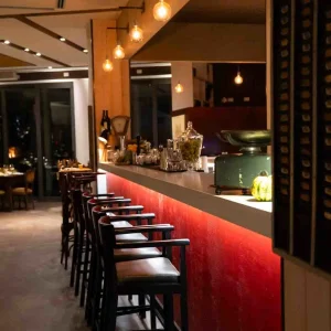 Un elegante bar con sgabelli e illuminazione soffusa in un'atmosfera accogliente.