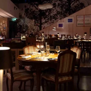 Un ristorante elegante con tavoli apparecchiati e illuminazione soffusa.